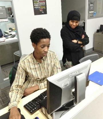 Shamar T., a Ben Franklin High School 11th Grade Student, and Hafsah Abdul-Malik, Computer Science Major at the College, Working on a History Project during Upward Bound After-school Tutoring