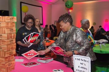 Vice President Lynette Brown-Sow play uno with an attendee.