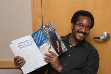 Featured dual admissions student, Mijuel Johnson, shows off his article in Pathways Magazine.