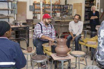 Roberto Lugo describes his technique as he spins a pot on the wheel