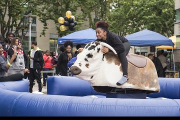 A rider's facial expression says it all as she tries not to slip off the Mechanical Bull ride.