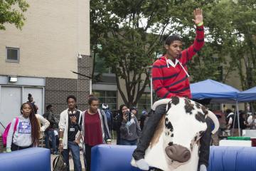 A rider makes it look easy as he raises a hand riding the Mechanical Bull.