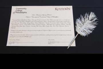 An image of the signed document and a feathered pen.
