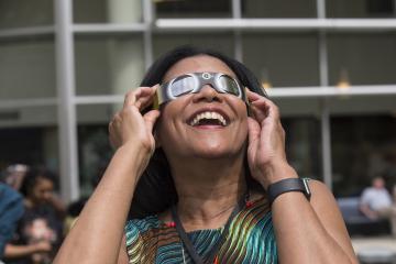 Vice President of Strategic Initiatives, Judy Gay, enjoys viewing the eclipse with eclipse glasses.