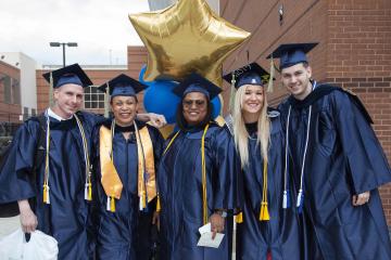 A group of graduates smile for the camera after the ceremony.