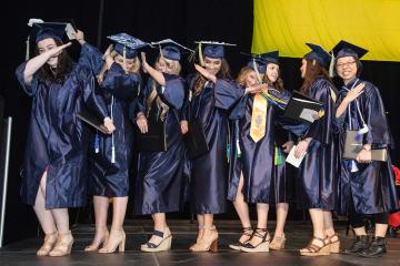 A group of graduates dances.