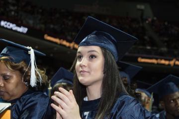 A graduate looks up toward the stage.