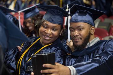 Two graduates take a selfie.