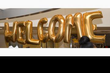 Balloons spelling out "Welcome" greet the students.
